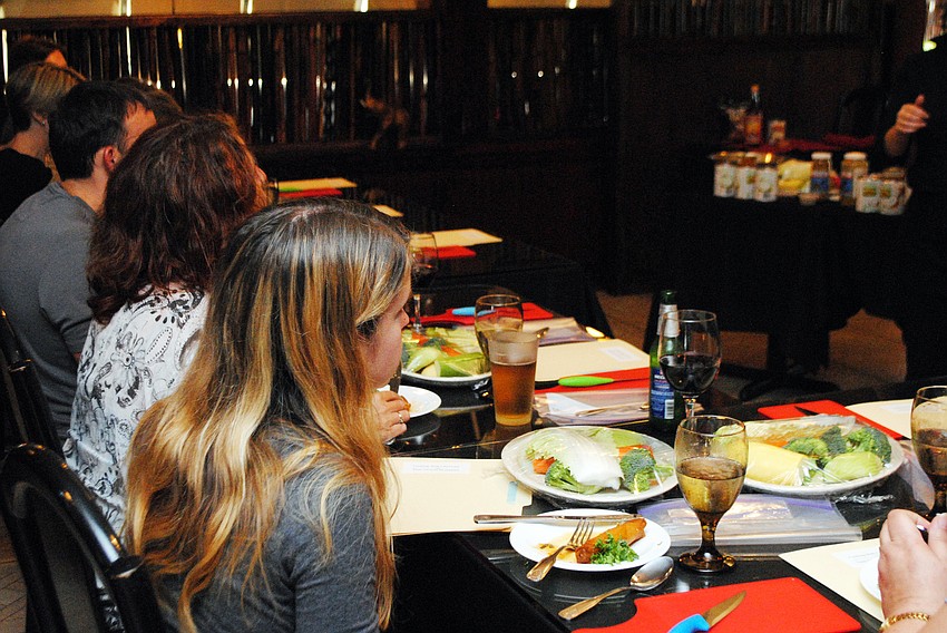 Students in Taste of Asiaâ€™s cooking class listen as Chef Lam Lum discusses what they will be preparing.