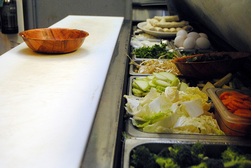 Chef Lam Lum prepares a rice noodle dish made primarily with vegetables.