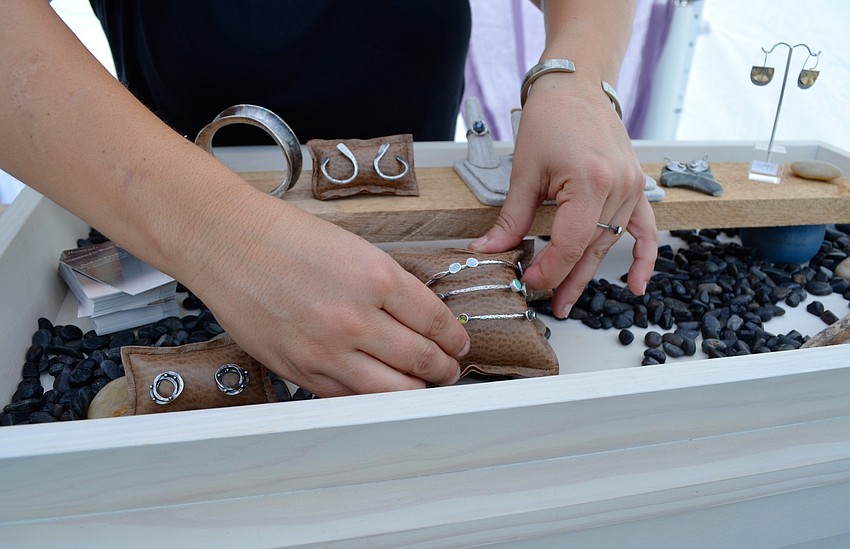 Wendy Thurlow arranges her handcrafted jewelry at her booth.
