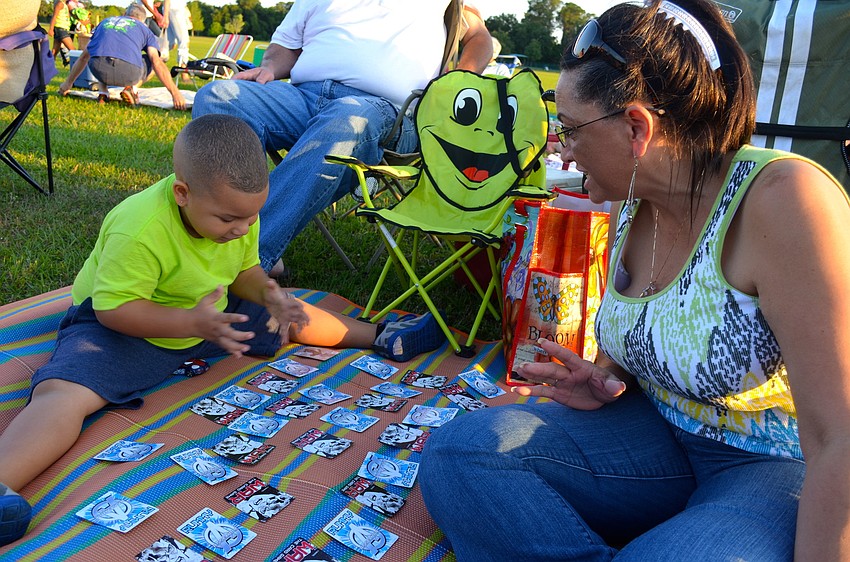 Fernando Nazario plays a card game with his grandmother, Dennis.