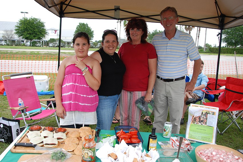 Jennifer and Alexis Fretz, Lisa Johnson, and Greg Hayes pose for a photo while perfecting their burgers for the hamburger contest.