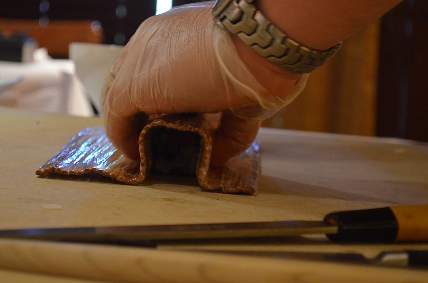 A makisu is a bamboo-rolling mat used to shape and form a roll of sushi