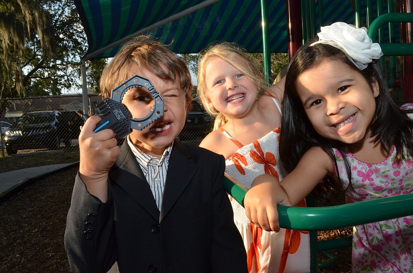 Quenton Newcomb, Addie Litherland and Sofia Beau play on the jungle gym after graduating from preschool.
