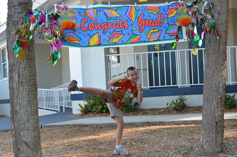 Ryan C. does a karate kick as he crosses the mulch.