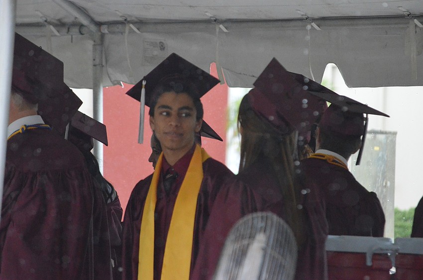 Glen Bright waited under a tent while it rained to head to the arena for the commencement.