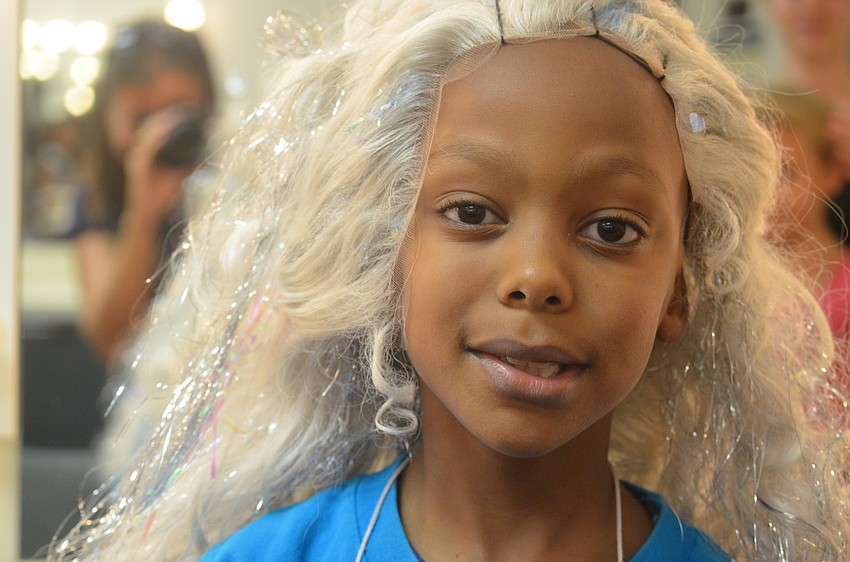 Nissi Luvavali puts on a sparkly white wig.