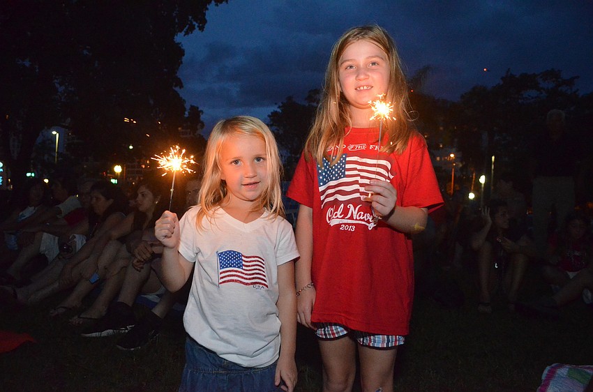 Sisters Reaghan and Emorie Lawrence play with sparklers at Bayfront Park.