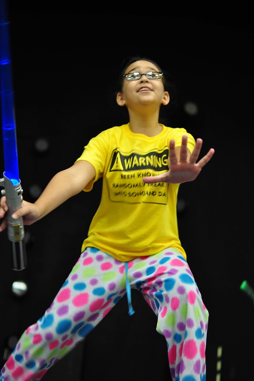 Gabby Macogay wields a sword, as she sings 