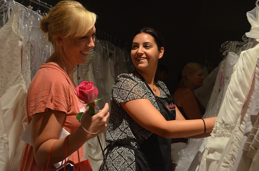 Volunteer Jessie Sheslow helps bride-to-be Heather Aubin search for a wedding dress. Aubin will marry Sept 22, 2013.