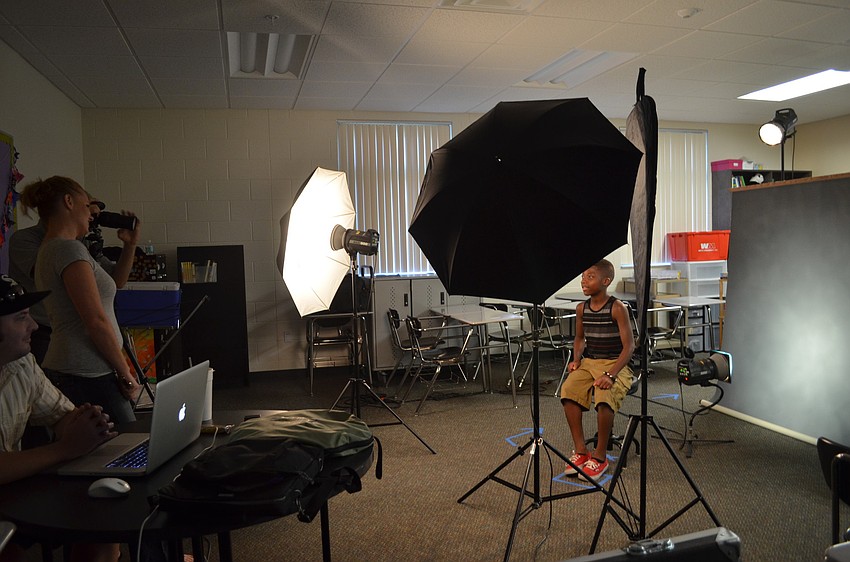 Thirteen-year-old Jeremiah Williams gets his school portrait taken by Booth Studio.