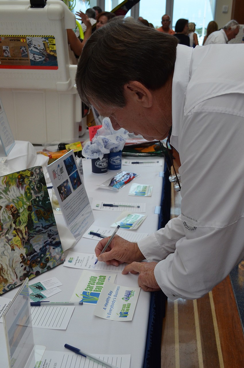 Rick Barth bids on the Oceanic mask and snorkel at the silent auction table.