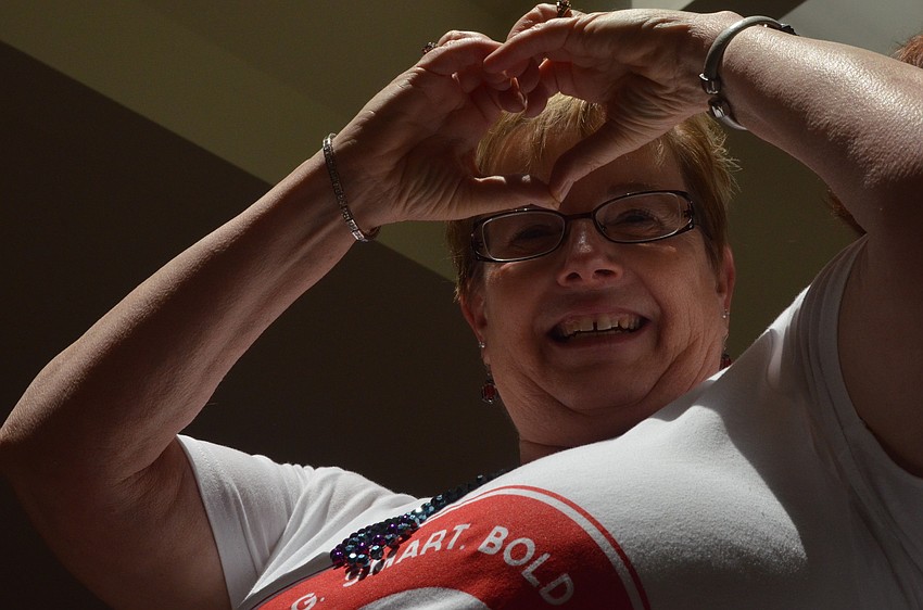 Bonnie Kritzmaches shows a heart to the audience and Girls Inc. girls.