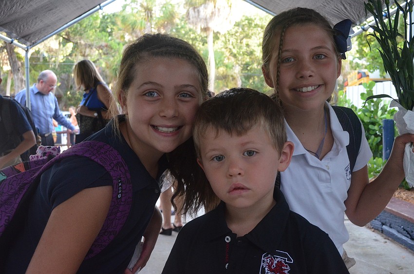 Alyssa R., 10, and her sister Katie, 9, say goodbye to their brother Max, 3, before heading to class.