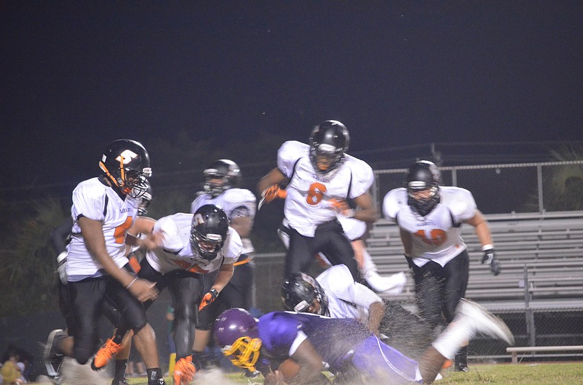 Booker High School football player catches the football and holds it tight to keep it away from Sarasota High School.