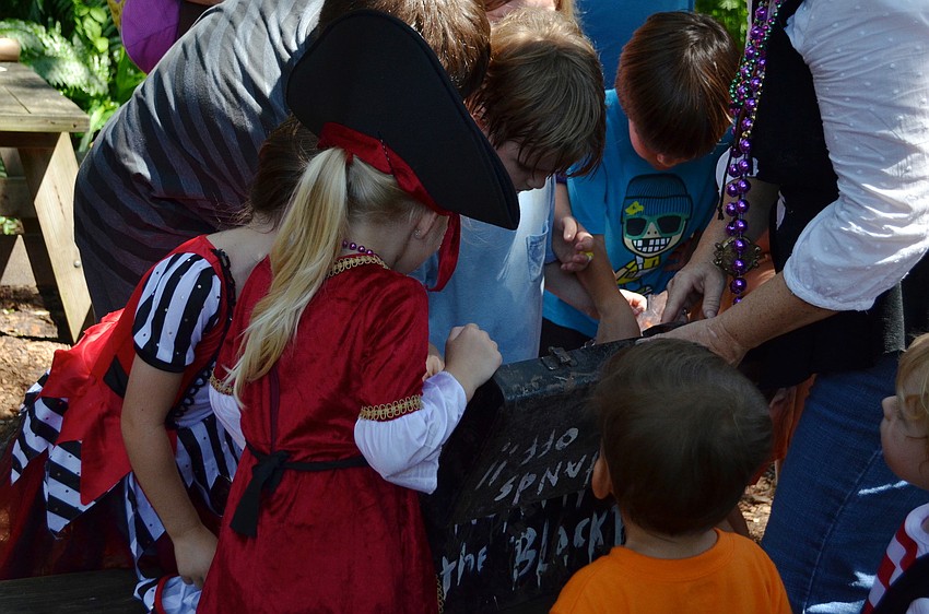 The children open the treasure chest they found on the hunt.