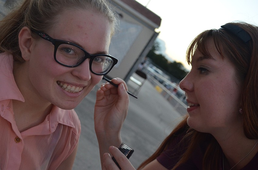 Sarah Coffey, 17, paints a paw on 17 â€“ year old Lexii Augustyniak â€˜s face to show of school spirit.