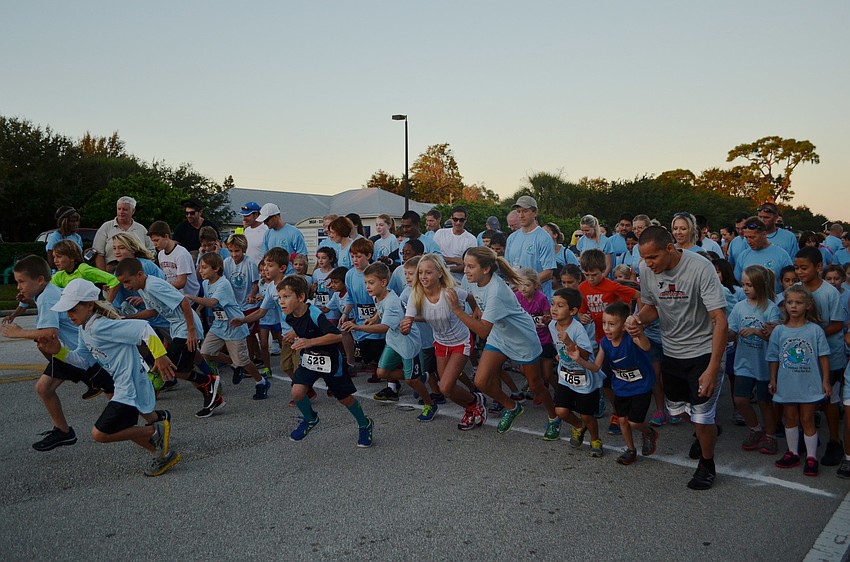 Runners in the 1 mile Fun Run race off the start line.