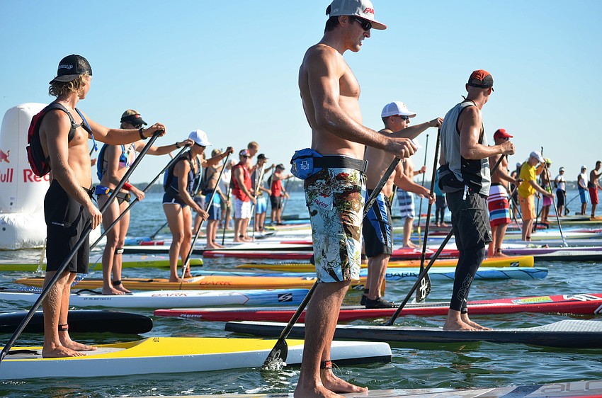 Paddleboarders line up at the start line.