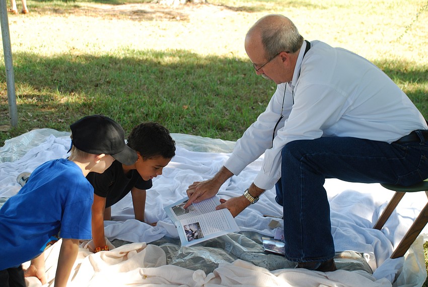 Sarasota Emergency Management Chief Ed McCrane reads to Mark Ruster and Jordan Banks