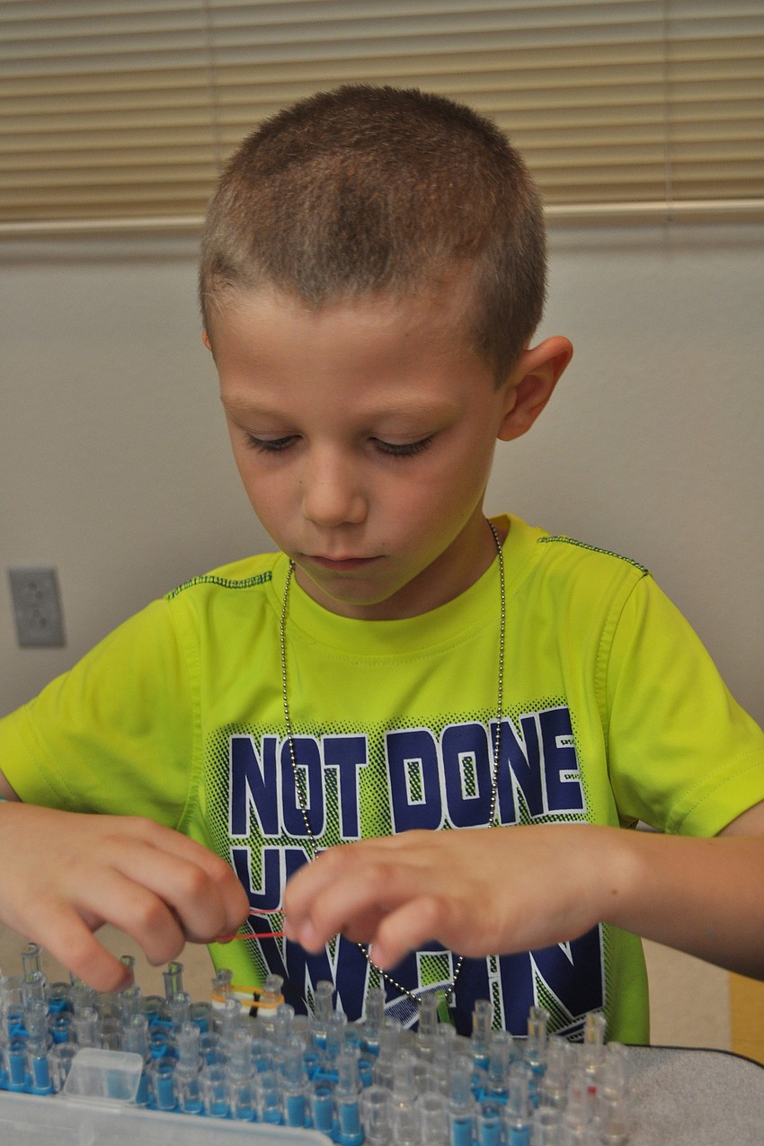 William Nash, 5, makes a bracelet.