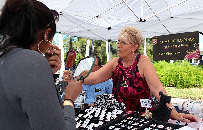 Donna Herman helps customers at her unique earring booth, Up the Ear.