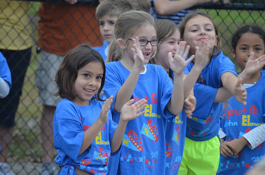 First graders Ashlynn McCoy, Hannah Adams cheer on runners.