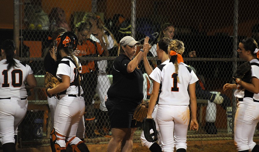 Sarasota coach Amy Nye congratulates her team after a scoreless third inning.