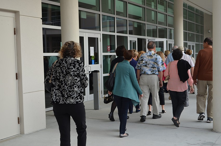 A long line waits to get into the auditorium at Riverview High School to hear Robert Edsel speak.