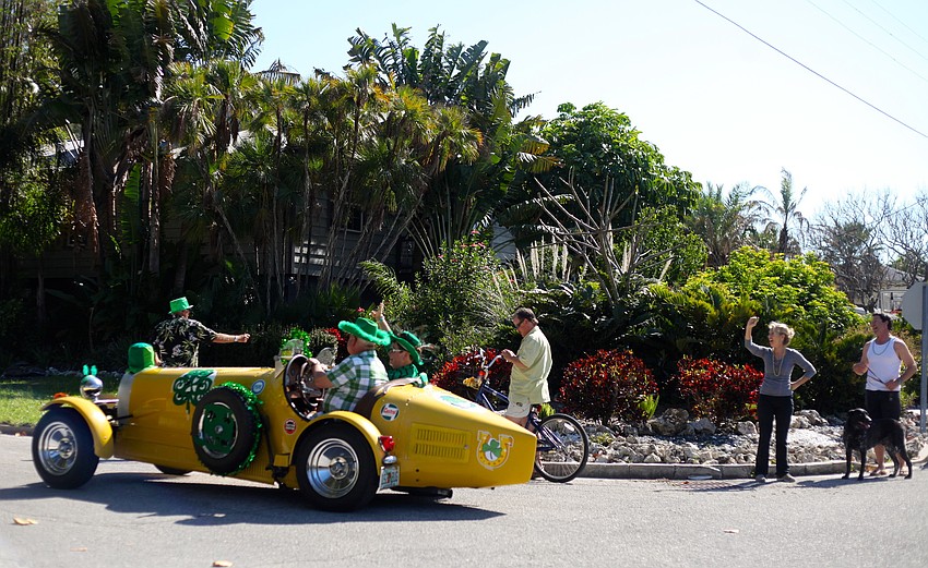 Neighbors gather on the sidewalks to cheer on the parade.