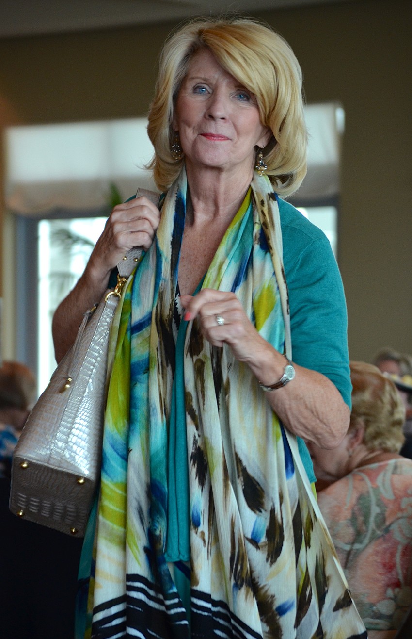 Barbara Gurchiek smiles as she walks around the room, showing off her colorful outfit.