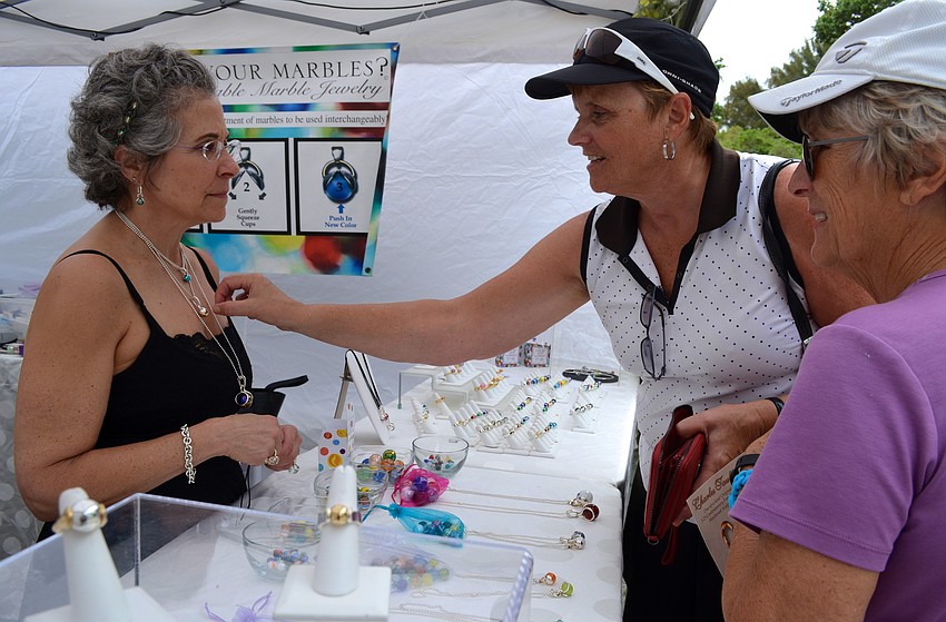 Lisa Stotska shows Judy Arndt and Betsy Bauernschmidt interchangeable marble jewelry.