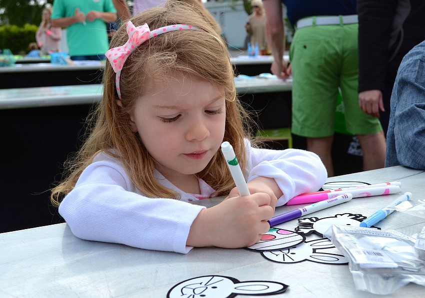 Mia Repenning colors an egg at one of the activity tables.