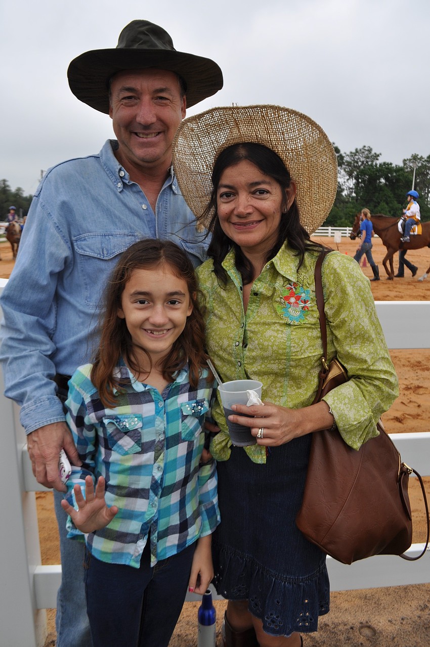 Sophia Norman and her parents, Jerry and Karla, watch her sister Natalie ride.