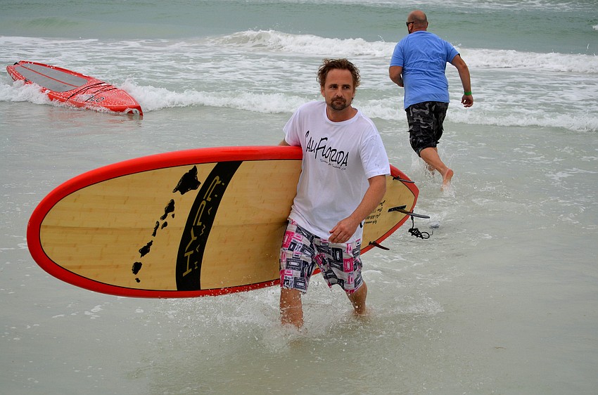 Blake Parsons helps runners put their boards on the beach.