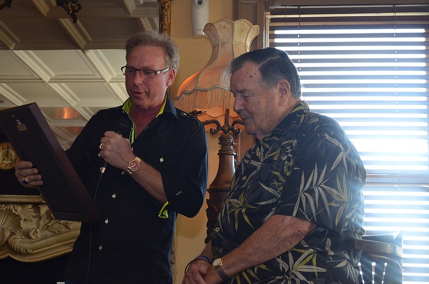 Ron Soto presents Paul Thorpe with a plaque from the Sarasota Downtown Merchants Association.