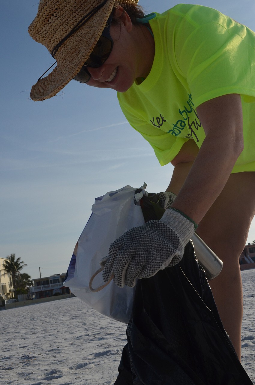 Michelle Stauffer throws away a rubber band she found on the beach.