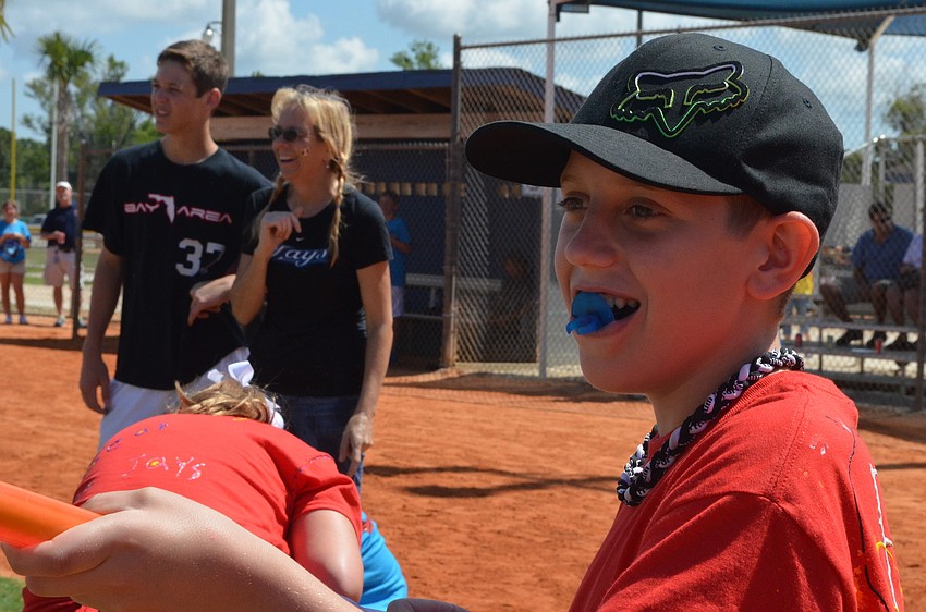Devin Juracka aims to get water in the bucket where his cousin and classmate Riley Stroth stands.