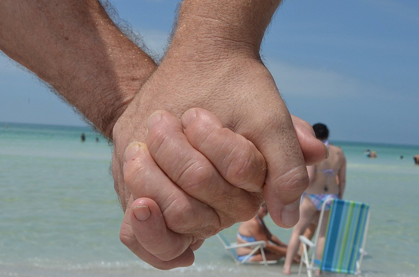 Community members join hands.