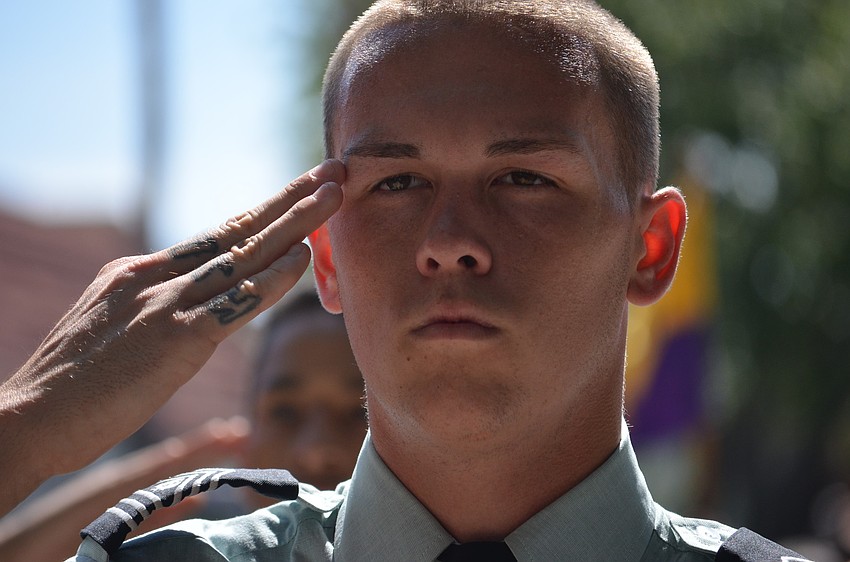 Booker High School JROTC cadet salutes veterans.