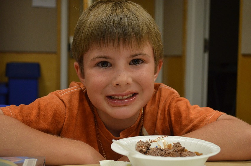 Rafe Raymond, 7, munches on some chocolate ice cream.