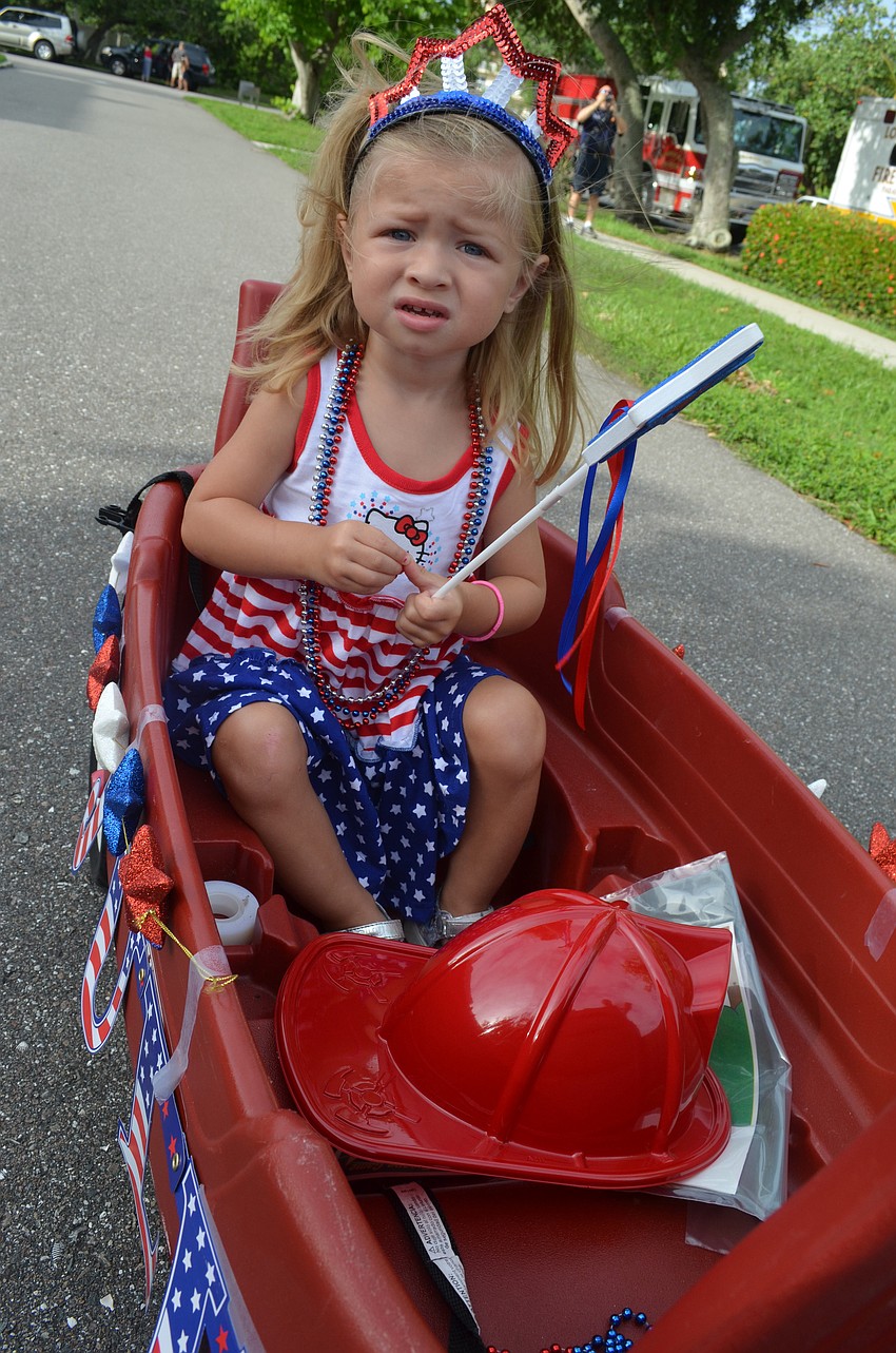 Mia Gubernat, 2, rides in her decorated wagon in the parade.