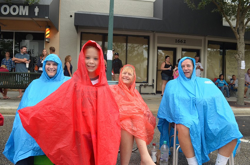 Christina Peterson wears a plastic raincoat with her son Connor, 4, and parents Vicki and Peter Wright.