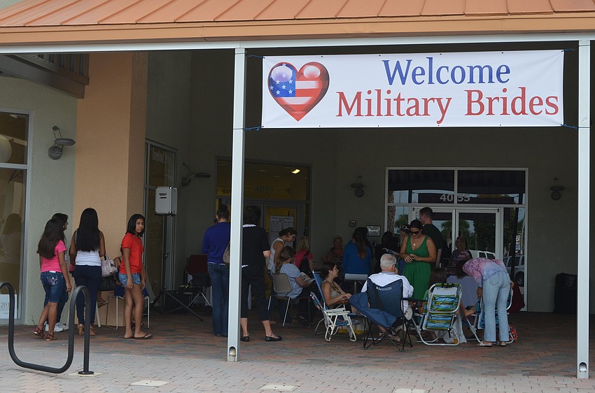 Ladies wait to be let in to Sarasota Brides and Formalwear Monday, July 16, to find their wedding gown.