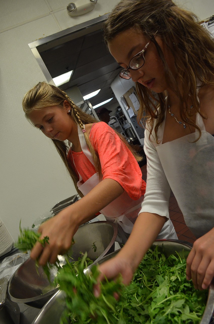 Samantha Reisky, 11, and Josie Filipanits, 10, prepare the salad.