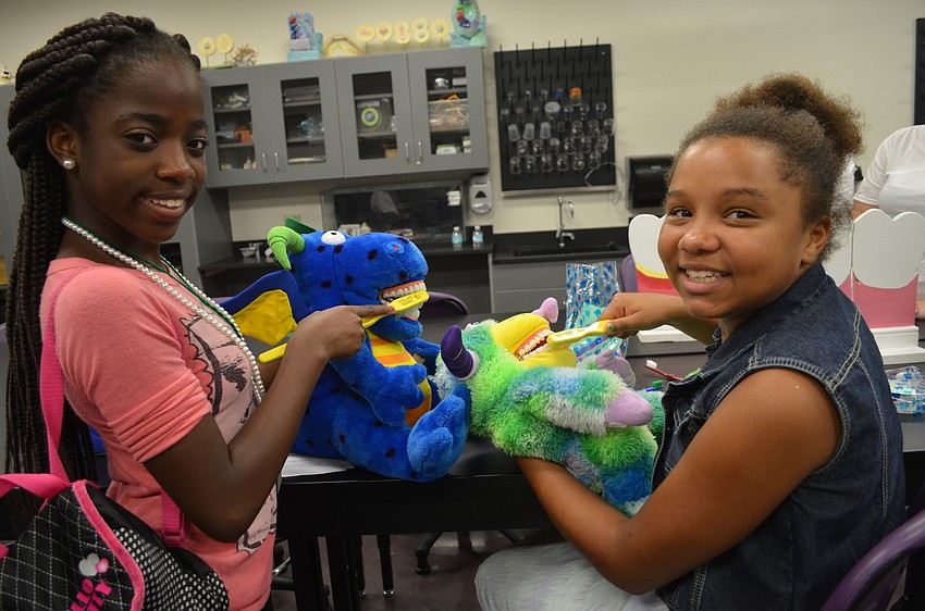 Jermia Williams, 14, and Maliah Gipson, 12, get instructions on how to properly brush teeth.
