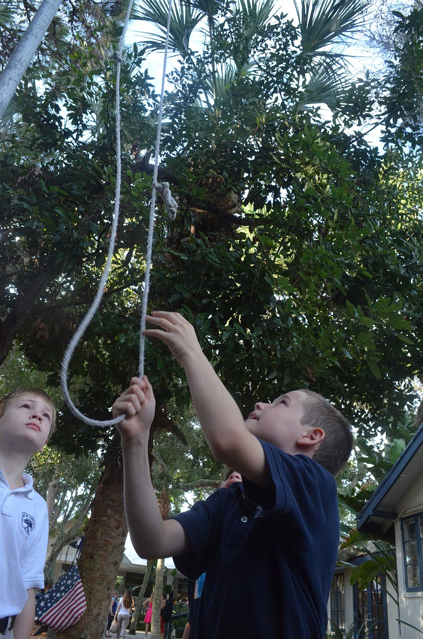 Calvin S. and E.J. R. raise the flag before class begins.