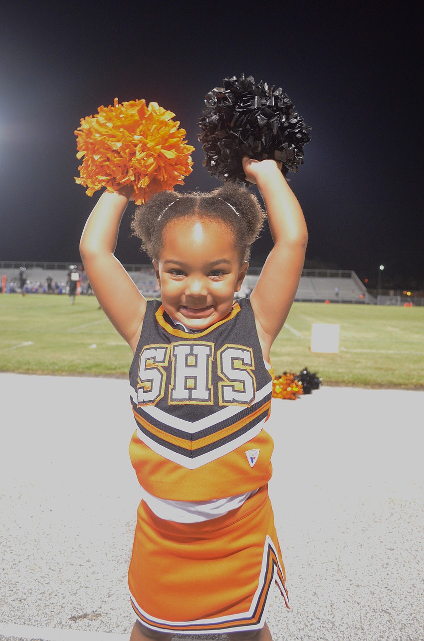 Charlie Miller, 2, hangs out with her sister Sydnie Battie and other cheerleaders.