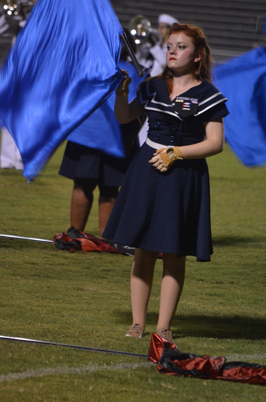 Sophomore Rose Marie Messina twirls a flag as part of the color guard during the halftime show.