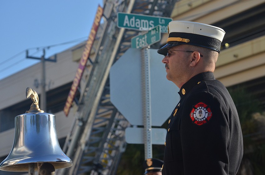 Sarasota County Fire Battalion Chief John Elwood rings the bell at 8:46 a.m. and 9:03 a.m. for moments of silence at the times the planes struck the north and south towers of the World Trade Center.