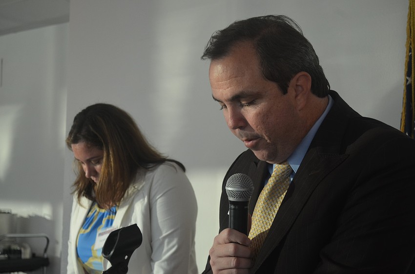 Joe Gruters leads more than 70 attendees in prayer before dinner.